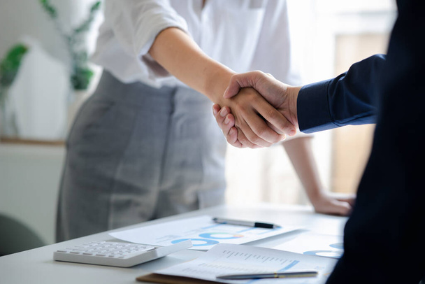 Business investor group holding hands, Two businessmen are agreeing on business together and shaking hands after a successful negotiation. Handshaking is a Western greeting or congratulation. - Foto, Imagen