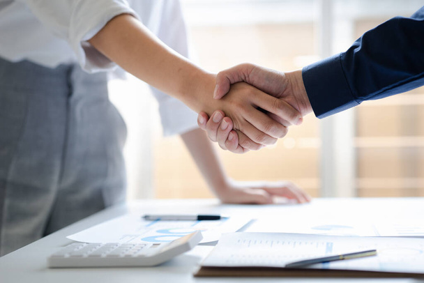 Business investor group holding hands, Two businessmen are agreeing on business together and shaking hands after a successful negotiation. Handshaking is a Western greeting or congratulation. - Fotó, kép