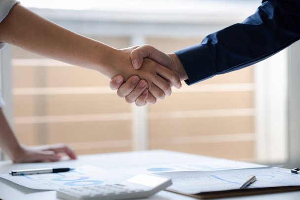 Business investor group holding hands, Two businessmen are agreeing on business together and shaking hands after a successful negotiation. Handshaking is a Western greeting or congratulation. - Фото, зображення