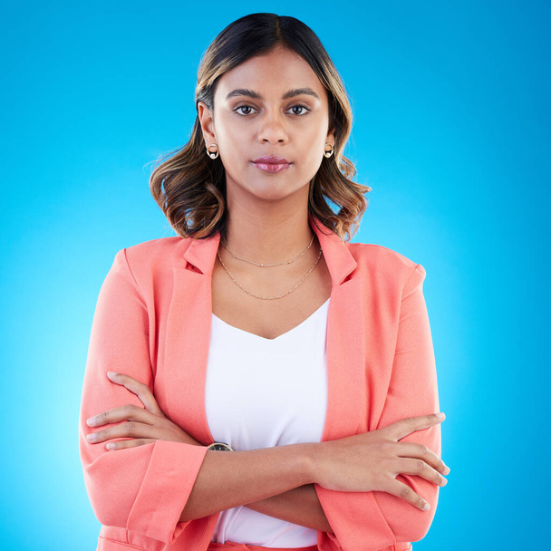 Serious, portrait and business woman with arms crossed in studio isolated on blue background with pride for career. Face, professional and confident, assertive or proud female entrepreneur from India. - Foto, imagen