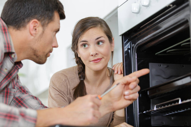 a couple checking an oven - Photo, Image