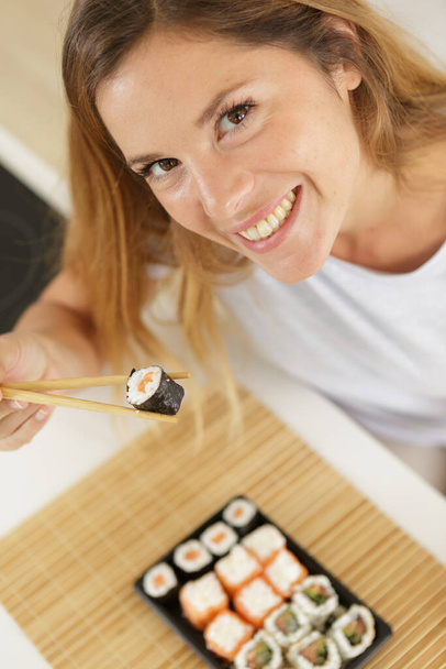 picture of woman eating sushi with chopsticks - Φωτογραφία, εικόνα