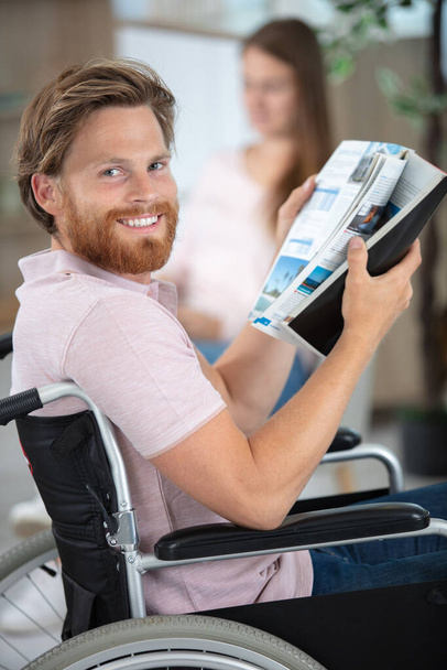 człowiek na wózku inwalidzkim czytający magasine - Zdjęcie, obraz
