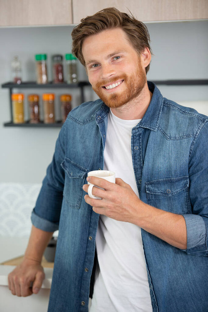 confident man at home holding a cup of coffee - Φωτογραφία, εικόνα