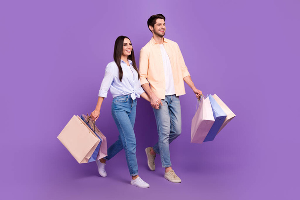 Full size profile photo of two attractive lovely people hold arms bags walk empty space isolated on purple color background. - Valokuva, kuva