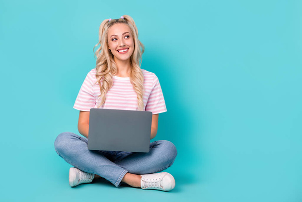 Full size portrait of lovely positive girl sit floor use netbook look empty space isolated on teal color background. - Φωτογραφία, εικόνα