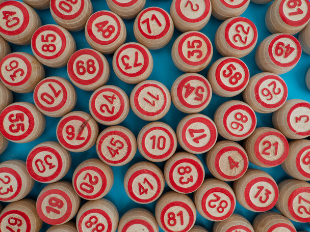 Επιτραπέζιο παιχνίδι μπίνγκο. Ξύλινα βαρέλια με αριθμούς λότο, παίζοντας χαρτιά για το παιχνίδι. Κοντινό πλάνο. - Φωτογραφία, εικόνα