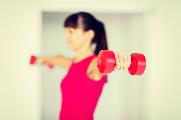 sporty woman hands with light red dumbbells - Foto, Bild