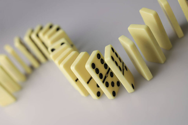 bordlogica spel voor de hele familie en vrienden van dominostenen. lichtgekleurde domino 's met zwarte stippen op een lichte en spiegelachtergrond - Foto, afbeelding