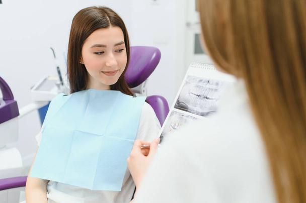 Dentist shows a patient x-ray of teeth. - Foto, Bild