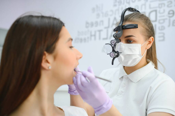 Young smiling woman with beautifiul teeth, having a dental inspection. - Фото, зображення