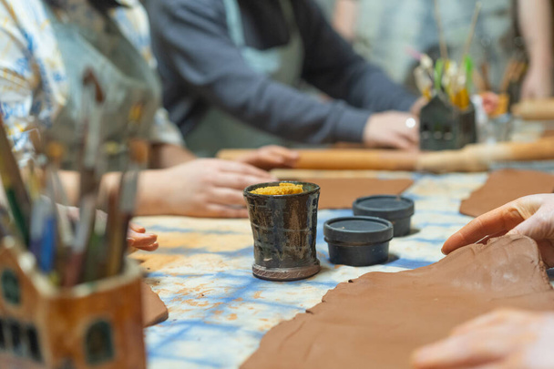 粘土製の陶器を作る人間の手を閉じてください。陶芸教室。ポッターは粘土、陶器から料理を作ります。クラフト、ワークショップで手作業で働く. - 写真・画像