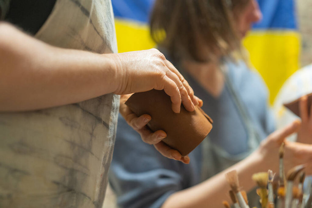 粘土のマグカップを作る人間の手を閉じます。陶芸教室。ポッターは粘土、陶器から料理を作ります。クラフト、ワークショップで手作業で働く. - 写真・画像