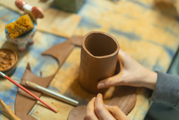 Gros plan de mains humaines faisant une tasse d'argile. Cours de poterie. Potter fait des plats à partir d'argile, de céramique. Artisanat, travail manuel dans l'atelier. - Photo, image