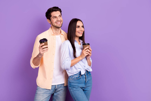 Photo de boisson positive tasse en papier jeune couple ensemble regardant rêveuse nouveau parfum cafétéria à emporter ad isolé sur fond de couleur violette. - Photo, image
