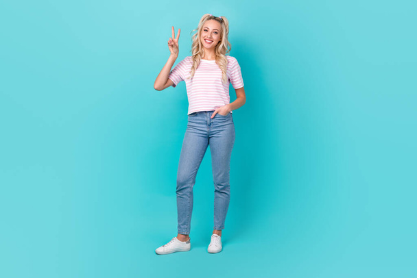 Full size portrait of satisfied pretty girl toothy smile arm fingers demonstrate v-sign isolated on teal color background. - Foto, imagen