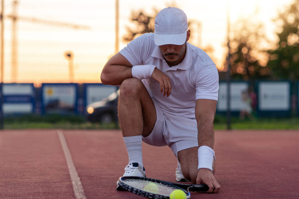 Sport. Primo piano dell'uomo, racchetta da tennis e palle sul campo da tennis. - Foto, immagini