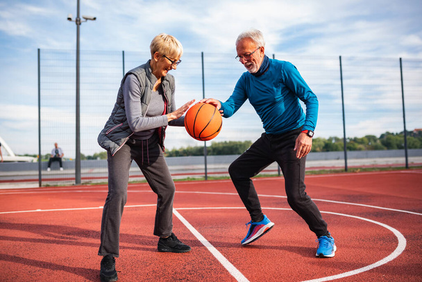 senior couple playing basketball outdoors - Foto, Imagem