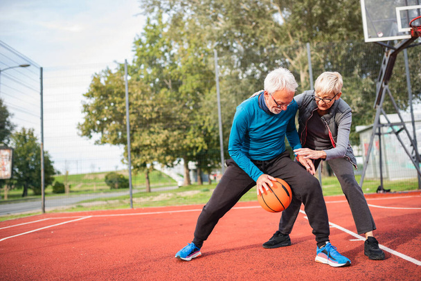 Couple âgé jouant au basketball en plein air
 - Photo, image