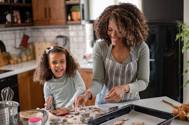 afro-amerikai anya és lánya együtt sütit főznek  - Fotó, kép