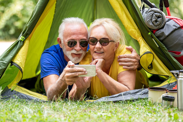 Senior couple of tourists enjoying in the forest.  - 写真・画像