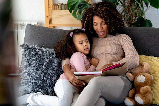 Afrikaans amerikaanse dochter en moeder lezen boek - Foto, afbeelding