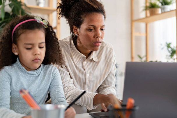 african american mother working at home with her daughter - Photo, Image