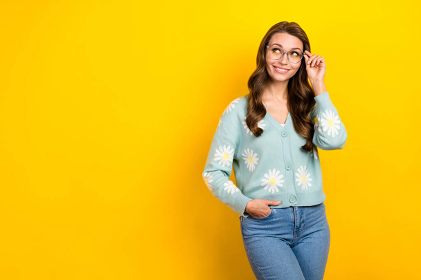 Photo of smart young girl curly hairdo touch eyewear new spectacles wear cardigan print flowers look empty space isolated on yellow color background. - Fotó, kép