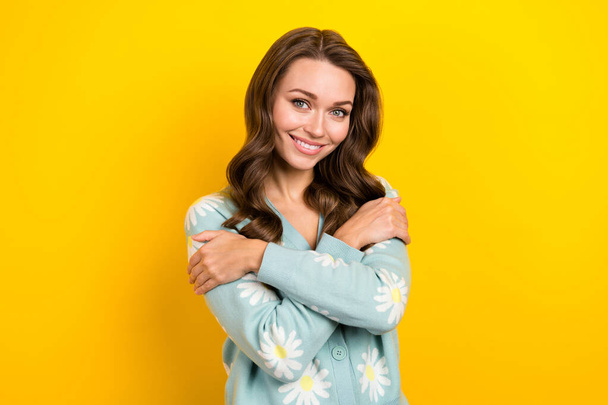 Closeup photo of lovely nice attractive lady hugs herself enjoy new print daisy cardigan valentine day holiday isolated on yellow color background. - Foto, Imagem