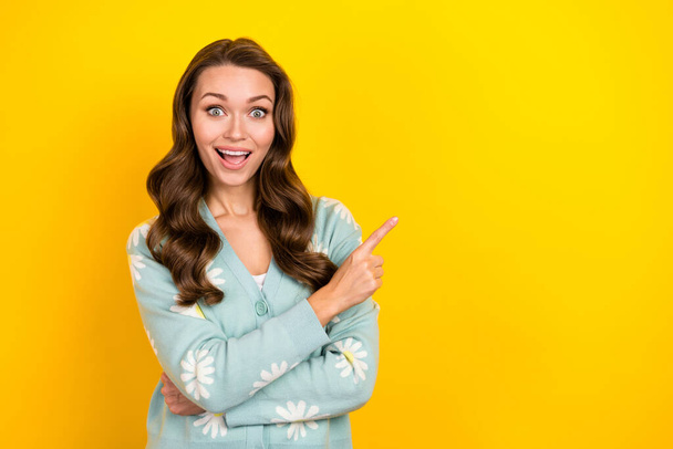 Photo of adorable excited woman wear turquoise cardigan pointing finger empty space isolated yellow color background. - Φωτογραφία, εικόνα
