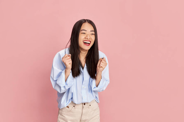 Portrait of young beautiful girl in casual clothes posing with happy smiling face against pink studio background. Concept of emotions, facial expression, fashion, youth, lifestyle. Ad - Photo, Image