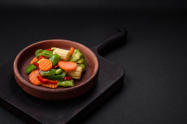 Herkullisia terveellisiä vihanneksia höyrytettyjä porkkanoita, parsakaalia, parsapapuja ja paprikaa tummalla betonitaustalla - Valokuva, kuva