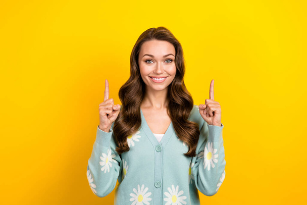 Photo of positive cheerful woman wear turquoise cardigan showing two fingers up emtpy space isolated yellow color background. - Фото, изображение