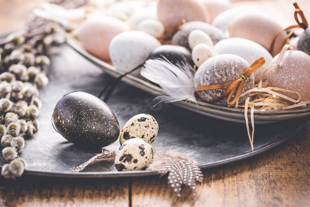 Easter eggs with pussy-willow branch on wooden kitchen table - Zdjęcie, obraz