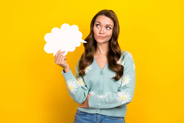 Photo of minded pensive girl hand hold empty space cloud shape card look contemplate isolated on yellow color background. - Fotó, kép