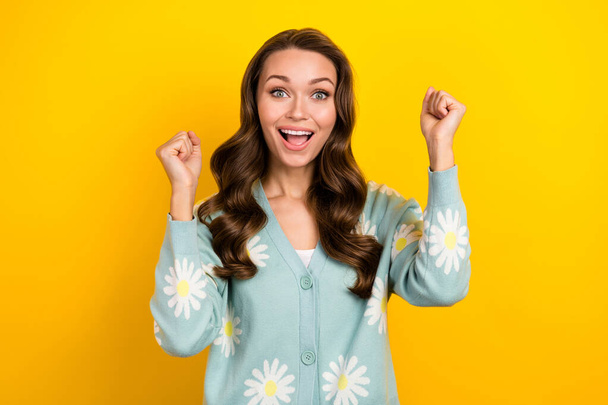 Photo of excited lucky woman wear turquoise cardigan screaming rising fists isolated yellow color background. - Фото, зображення