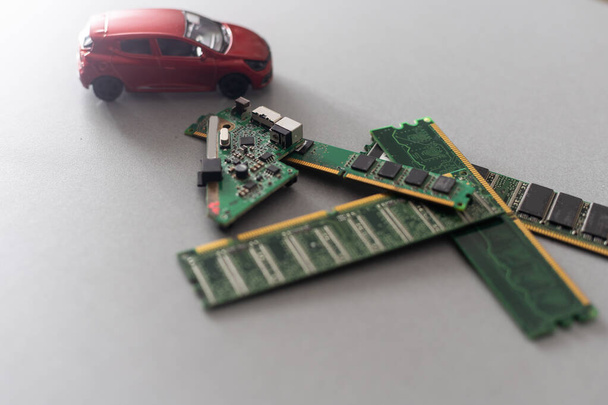 Toy cars on an electronic board with integrated circuits. The shortage of microchips and semiconductors creates a shortage of new cars. semiconductor shortage concept - Zdjęcie, obraz