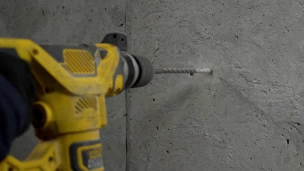 Buena reparación. Clip. Un taladro amarillo perfora pequeños agujeros en la pared. Imágenes de alta calidad 4k - Metraje, vídeo