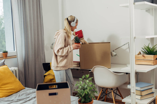 A college student is unpacking her stuff from boxes - Fotoğraf, Görsel