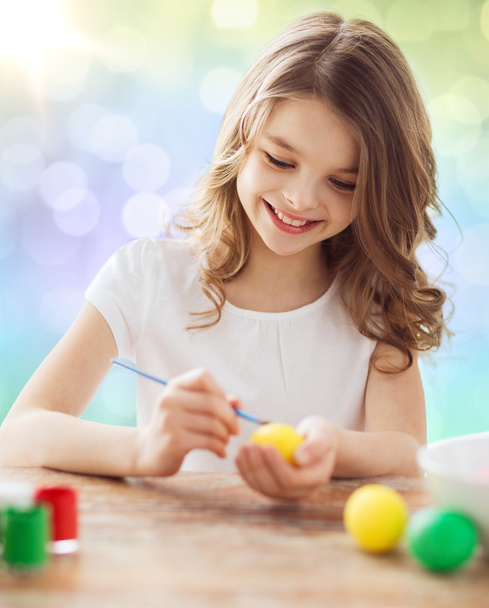 happy girl with brush coloring easter eggs - Foto, Imagen