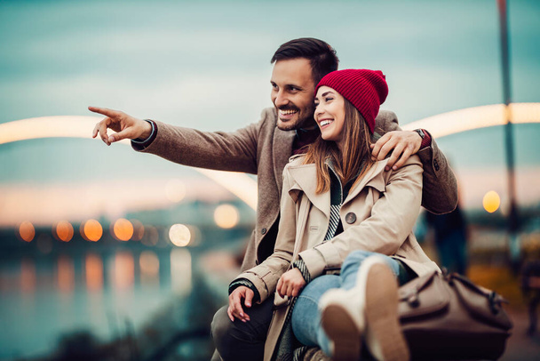Loving young couple hugging and smiling together in the city. - Photo, image