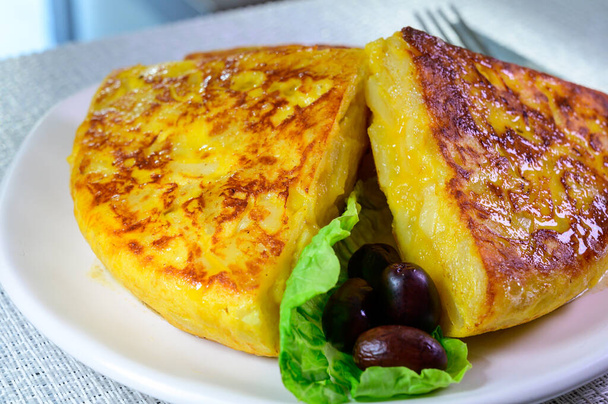 Spanish vegetarian food, portion of homemade tasty potato omelette tortilla de patatas with onion served on terrace in morning sunlights - Fotografie, Obrázek