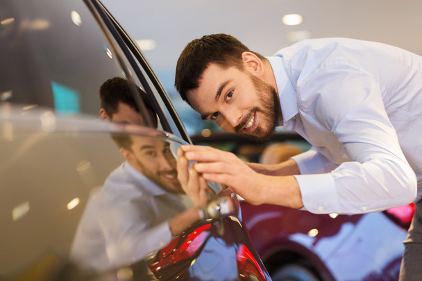 happy man touching car in auto show or salon - Zdjęcie, obraz