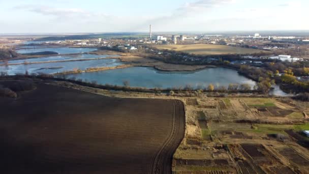Urban beautiful landscape agricultural plowed fields, lakes for growing fish, gardens, plants,building industrial area of city, cloud shadows on sunny autumn day. Aerial drone view. - Footage, Video