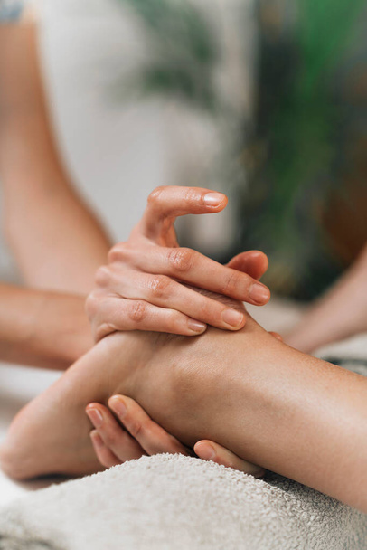 Ayurvedic Foot Massage. Hands of Ayurveda Practitioner massaging female foot  - 写真・画像