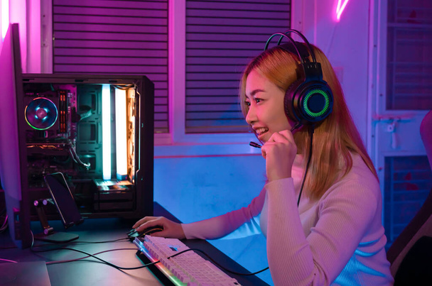 A Professional female pro gamer play online video games cyber sport and esport winner emotion. Young woman in tournament match worldwide in room colorful neon lights. - Photo, image