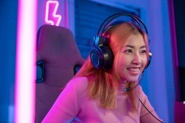A Professional female pro gamer play online video games cyber sport and esport winner emotion. Young woman in tournament match worldwide in room colorful neon lights. - Фото, зображення