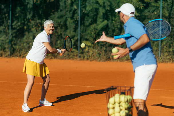 Aktiivinen vanhempi nainen harjoitellaan tennis - Valokuva, kuva