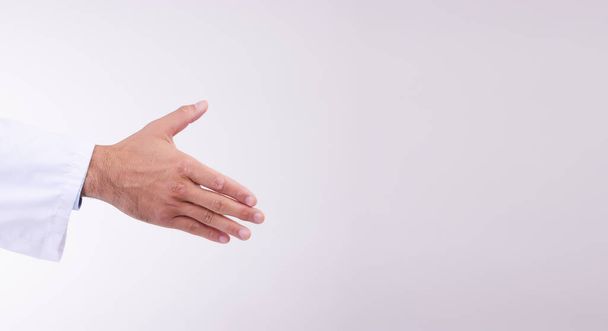 Doctor, handshake and mockup for healthcare partnership, meeting or greeting against a white studio background. Hand of isolated medical professional shaking hands for introduction, deal or thank you. - Photo, image