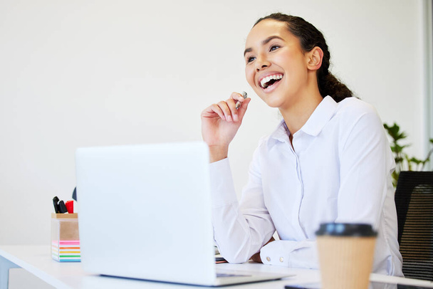 Naucz się kochać to, co robisz. atrakcyjna młoda bizneswoman siedzi sama w biurze i korzysta z laptopa - Zdjęcie, obraz